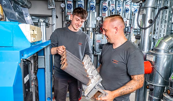 Symbolbild Ausbildung - Mitarbeiter und Auszubildender am Arbeitsplatz